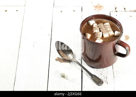 Heißer Schokoladendrink in einem emaillierten Becher aus Vintage-Emaille auf Holzhintergrund Stockfoto