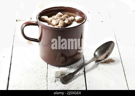 Heißer Schokoladendrink in einem emaillierten Becher aus Vintage-Emaille auf Holzhintergrund Stockfoto