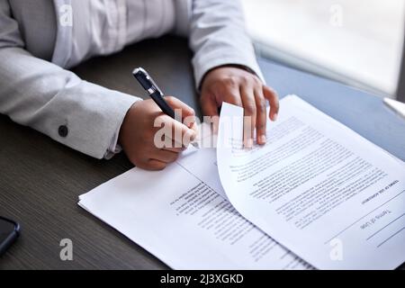Lassen Sie uns den Papierkram aus dem Weg. Eine kurze Aufnahme einer Geschäftsfrau, die in einem Büro Schreibarbeiten unterschrieb. Stockfoto