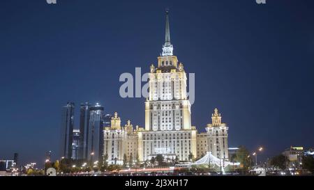 Stadtbild in der Nacht mit beleuchteten Wolkenkratzern in Moskau im stalinistischen Stil. Aktion. Wunderschönes Gebäude an einem dunkelblauen Abendhimmel Stockfoto