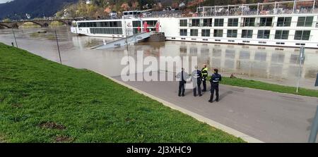 Trier, Deutschland. 10. April 2022. Polizisten stehen neben dem Alsvin-Schiff am Ufer der Mosel. In Trier blieb das Schiff mit 102 Passagieren und 50 Besatzungsmitgliedern wegen des hohen Wassers an der Mosel hängen und konnte nicht mehr abreisen. Nach Angaben der Wasserpolizei steht die Anlegebrücke seit Samstag unter Wasser, und Passagiere können das Schiff nicht verlassen. Die Rettungsdienste bieten derzeit Notfallversorgung für die an Bord befindlichen Personen an. Quelle: Sebastian Klemm/dpa/Alamy Live News Stockfoto