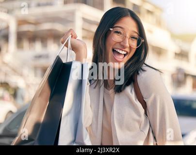 Die besten Einkäufe der Saison. Porträt einer attraktiven jungen Frau, die beim Einkaufen in der Stadt allein nach draußen geht. Stockfoto