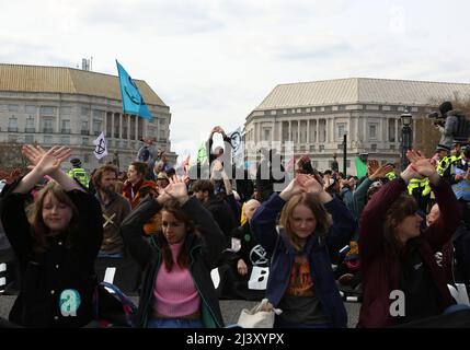 London, Großbritannien. 09. April 2022. Die Demonstranten signalisieren, dass sie sitzen, während sie die Lambeth Bridge in London blockieren, um gegen den Klimawandel und fossile Brennstoffe zu protestieren. 10.. April 2022. Anna Hatfield/ Pathos Credit: Pathos Images/Alamy Live News Stockfoto