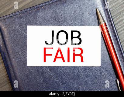 Weißer Notizblock und Tintenstift auf dem Holzschreibtisch Job Fair Concept. Stockfoto