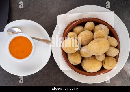 Papas arrugadas in Tonteller und würziger Mojo-Sauce auf der Seite von oben. Traditionelle Knitterkartoffeln von der Insel Gran Canaria, Spanien Stockfoto