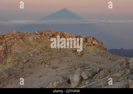 Vulkanisches Gestein auf dem Gipfel des Teide mit Schwefel bedeckt, 3718 m hoher Berg, der im Morgengrauen Schatten wirft, Teide Nationalpark Teneriffa Kanarische Inseln Stockfoto