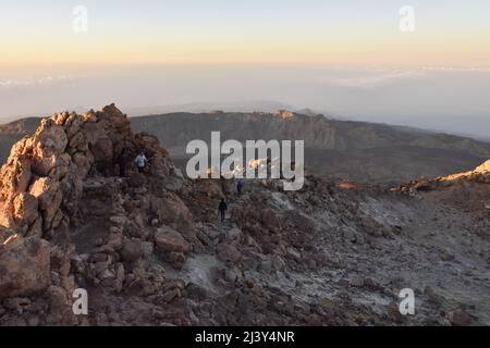 Wanderer auf felsigen Weg Abstieg vom Gipfel des Teide (3718 m Höhe) am Morgen, Teide Nationalpark Teneriffa Kanarische Inseln Spanien. Stockfoto