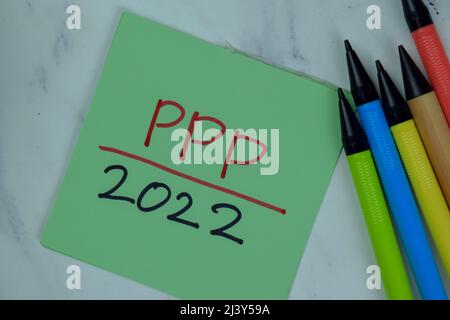 PPP 2022 Schreiben Sie auf Haftnotizen isoliert auf Holztisch. Stockfoto