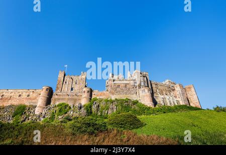 Die Außenmauern des berühmten Bamburgh Castle an der Nordostküste Englands, neben dem Dorf Bamburgh in Northumberland, einem denkmalgeschützten Gebäude Stockfoto