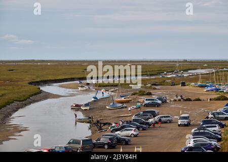 Kleine Boote und Autos parkten bei Ebbe an der Flussmündung des Glaven in Blakeney, einem kleinen Küstendorf an der Nordküste Norfolk, East Anglia Stockfoto