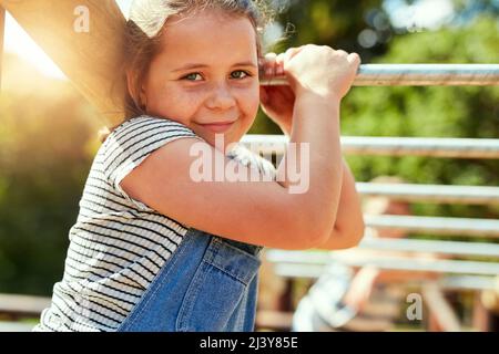 Spielzeit ist die beste Zeit. Porträt eines kleinen Mädchens, das im Dschungel-Fitnessstudio im Park spielt. Stockfoto