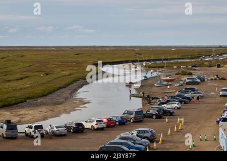 Kleine Boote und Autos parkten bei Ebbe an der Flussmündung des Glaven in Blakeney, einem kleinen Küstendorf an der Nordküste Norfolk, East Anglia Stockfoto