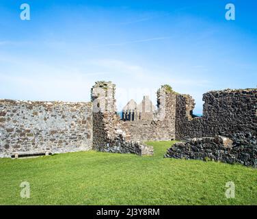 Das berühmte Dunluce Castle ruiniert an einem sonnigen Tag in Nordirland. Stockfoto