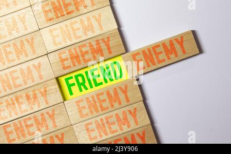 FEINDLICHES Wort auf Holzblock geschrieben, Stockfoto