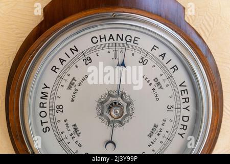 Britische machten antikes aneroides Barometer mit einem Gesicht, das stürmisch, regnerisch, wechselhaft, fair und sehr trocken zeigte und derzeit eine Wetteränderung prognostizierte. VEREINIGTES KÖNIGREICH Stockfoto