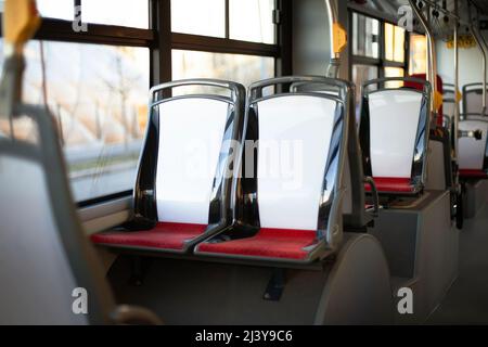 Sitze im öffentlichen Nahverkehr. Modernes Stadtbusinterieur. Moderne Inneneinrichtung und Sitze im Stadtbus. Öffentliche Verkehrsmittel. Stockfoto