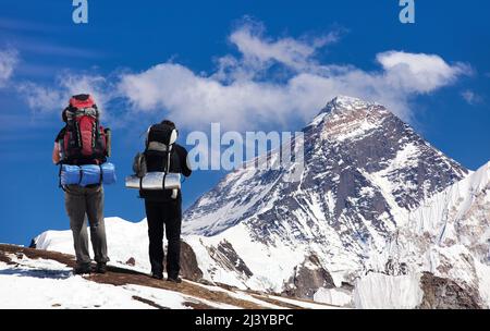 Mount Everest gesehen vom Gokyo Tal mit zwei Touristen auf dem Weg zum Everest Basislager, Sagarmatha Nationalpark, Khumbu Tal, Nepal Himalaya Mount Stockfoto