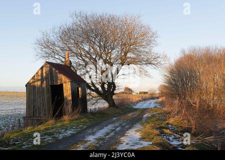 Eine verlassene Linesman's Hut an der Seite des Formartine & Buchan Cycleway in Aberdeenshire in Winter Sunshine Stockfoto