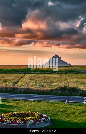 Wolkiger orangefarbener Sonnenuntergang über dem Mont Saint Michel, Normandie, Frankreich Stockfoto