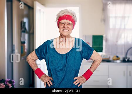 Aufrechterhaltung eines aktiven Lebensstils unabhängig vom Alter. Aufnahme einer älteren Frau, die zu Hause trainiert. Stockfoto