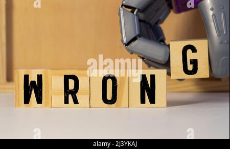 Buchstabenblock im Wort falsch auf Holzhintergrund. Stockfoto