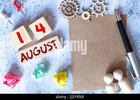 Kalender mit trendigen blauen Text und Zahlen für August 14 und ein Geschenk in einer Box Stockfoto