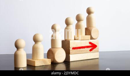 Silhouette Ausschnitte eines Mannes zu Fuß bis Holz- schritte mit Dominos über alten rauhen Holztisch Oberfläche. Stockfoto