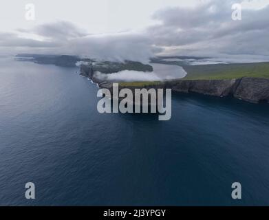 Wunderschöne filmische Luftaufnahme des Wasserfalls von Bøsdalafossur und des Sees von Trælanípan - Lagune herrliche Wahrzeichen auf den Färöer Inseln Stockfoto