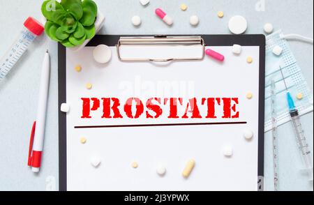 Weißer Notizblock mit den Worten Prostatakrebs und einem Stethoskop auf blauem Hintergrund. Medizinisches Konzept. Stockfoto