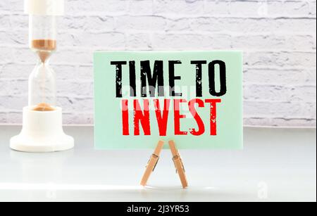 Visitenkarte mit Text Time to Invest liegt auf Finanzkarten mit Stift und Brillen. Finanz- und Geschäftskonzept Stockfoto