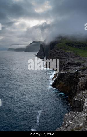 Wunderschöne filmische Luftaufnahme des Wasserfalls von Bøsdalafossur und des Sees von Trælanípan - Lagune herrliche Wahrzeichen auf den Färöer Inseln Stockfoto