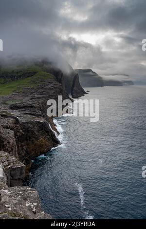 Wunderschöne filmische Luftaufnahme des Wasserfalls von Bøsdalafossur und des Sees von Trælanípan - Lagune herrliche Wahrzeichen auf den Färöer Inseln Stockfoto
