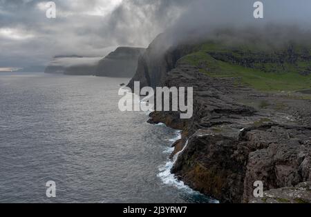 Wunderschöne filmische Luftaufnahme des Wasserfalls von Bøsdalafossur und des Sees von Trælanípan - Lagune herrliche Wahrzeichen auf den Färöer Inseln Stockfoto
