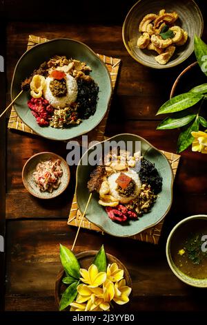 Nasi Campur Babi Guling. Balinesisches Gericht mit Reis und Schweinebraten, anderen Schweinefleisch- und Gemüsegerichten Stockfoto