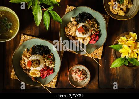 Nasi Campur Babi Guling. Balinesisches Gericht mit Reis und Schweinebraten, anderen Schweinefleisch- und Gemüsegerichten Stockfoto