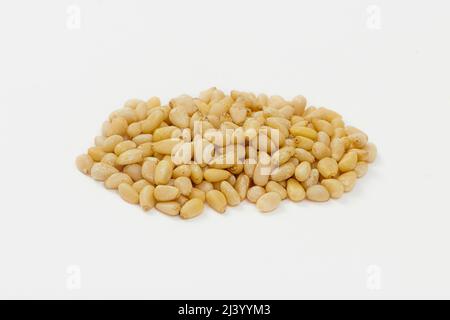 Haufen von Pinienkerzen isoliert auf weißem Hintergrund. Geschälte Zedernsamen Stockfoto