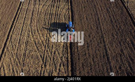 Traktorfahrer auf Traktorpflügen landen. Antenne. Landwirt im Traktor Pflügen Boden Stockfoto