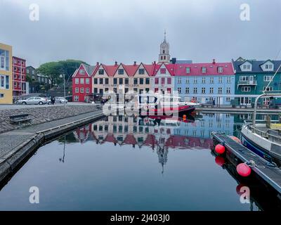 Blick auf die wunderschöne Stadt Torshavan auf den Färöer Inseln und bunte Häuser und Restaurants mit hellen Farben und Gras auf den Dächern in der Nähe Stockfoto