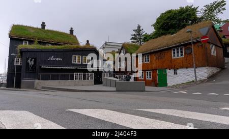 Blick auf die wunderschöne Stadt Torshavan auf den Färöer Inseln und bunte Häuser und Restaurants mit hellen Farben und Gras auf den Dächern in der Nähe Stockfoto