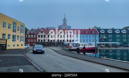 Blick auf die wunderschöne Stadt Torshavan auf den Färöer Inseln und bunte Häuser und Restaurants mit hellen Farben und Gras auf den Dächern in der Nähe Stockfoto