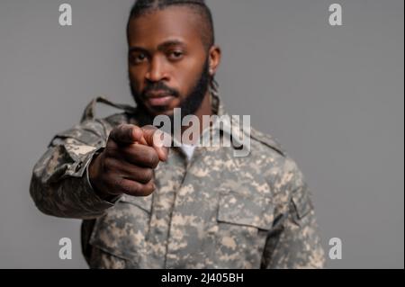 Porträt eines ernsthaft fokussierten Militärs, der in einer Khaki-Uniform gekleidet ist und vor die Kamera stochert Stockfoto