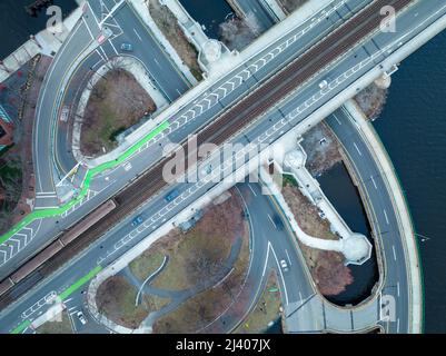 Luftaufnahme von oben nach unten von der Longfellow Bridge U-Bahnstation mit Memorial Drive über dem Wasser in Boston, während die U-Bahn des Nahverkehrs vorbeifährt Stockfoto