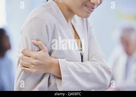 Es war eine harte Woche im Büro. Kurzer Schuss einer Geschäftsfrau, die ihren Arm vor Schmerzen hält. Stockfoto