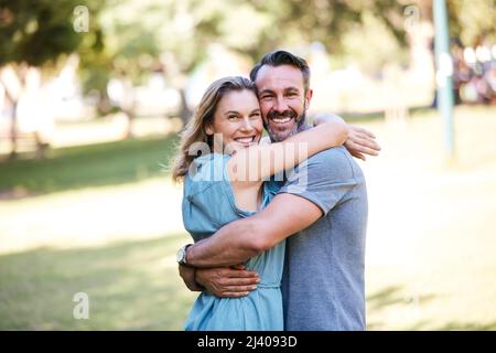 Hes gut aussehend und hat alles meins. Aufnahme eines glücklichen Paares, das sich im Park umarmt. Stockfoto