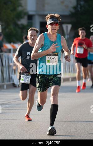 Austin, Texas, USA. 10. April 2022. Stephen Charters, 50, aus Oxford, Großbritannien, kommt 134. von über 21.000 Teilnehmern, die am Rennen in Austin teilnehmen. Mehr als 15.000 Menschen nahmen am Capitol 10.000 Teil, einem Lauf 10K, der von der lokalen Tageszeitung, dem Austin American Statesman, durchgeführt wurde. Die ersten Finisher der Cap10K überquerten die Linie in etwas mehr als 30 Minuten. Kredit: Sidney Bruere/Alamy Live Nachrichten Stockfoto