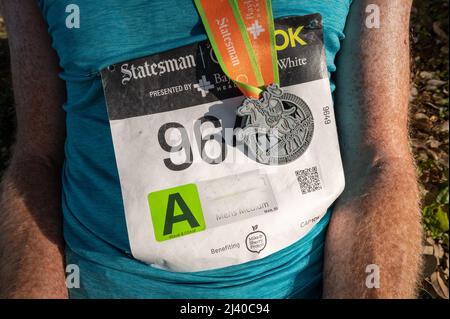 Austin, Texas, USA. 10. April 2022. Medaille für die Teilnehmer. Mehr als 15.000 Menschen nahmen am Capitol 10.000 Teil, einem Lauf 10K, der von der lokalen Tageszeitung, dem Austin American Statesman, durchgeführt wurde. Die ersten Finisher der Cap10K überquerten die Linie in etwas mehr als 30 Minuten. Kredit: Sidney Bruere/Alamy Live Nachrichten Stockfoto