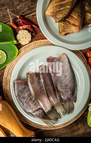 Frischer Fisch auf dem Tisch garniert mit Gemüse Stockfoto