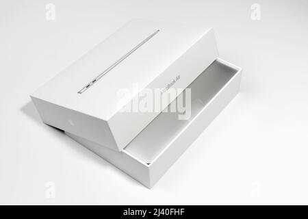 Saratov, Russland - 26. Februar 2022: Offene Verpackung des neuen silbernen Macbook Air 13 Zoll mit M1 Prozessor, Auspacken topview, weißer Hintergrund Stockfoto