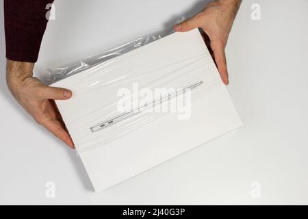 Saratov, Russland - 26. Februar 2022: Transparente Verpackung von neuem Macbook Air 13 Zoll mit M1 Prozessor topview, weißer Hintergrund Stockfoto