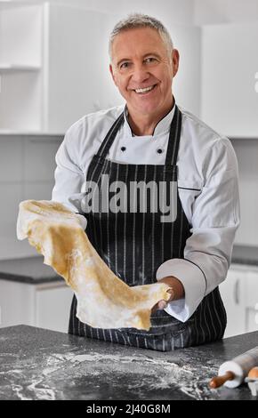 Begierde Kohlenhydrate Ich habe Sie bedeckt. Porträt eines reifen Mannes, der frisch zubereitete Pasta zubereitet. Stockfoto